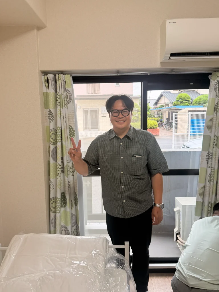 新しい住居への入居を終え、笑顔を見せるビルさん